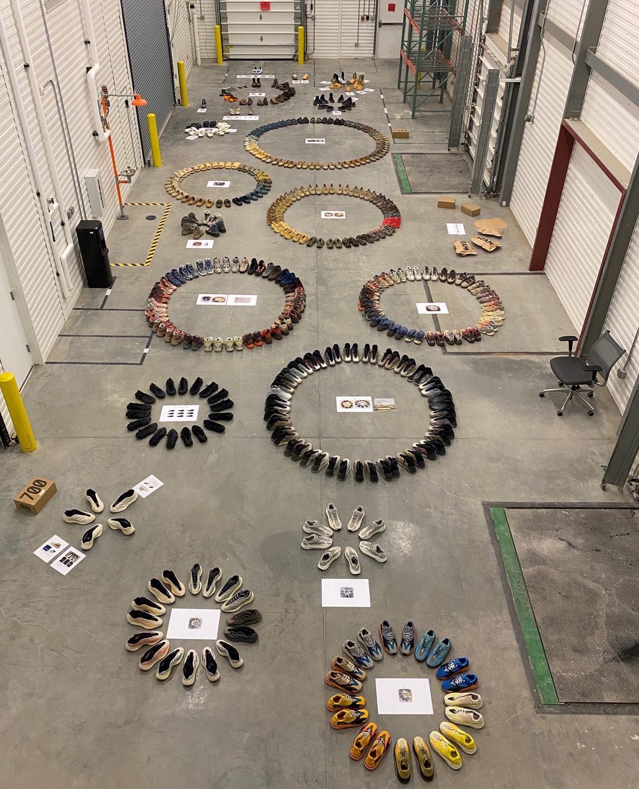 Yeezy footwear arranged into tonal colour rings on a warehouse floor, each keyed to a reference card